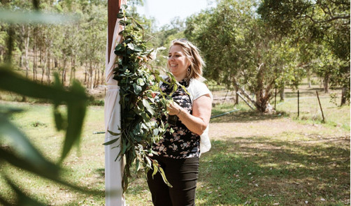 image of Sharon, lead event planner and creative director, arranging flowers in a country environment